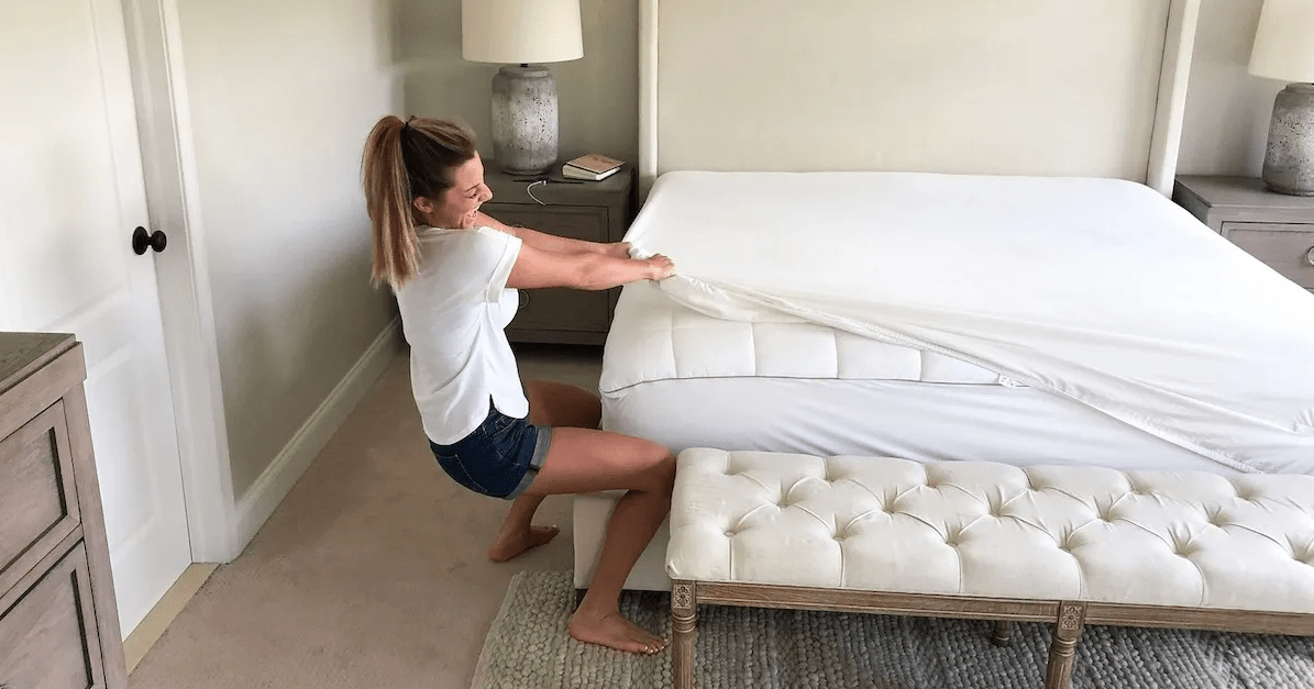A person struggling to pull a fitted sheet over a mattress corner